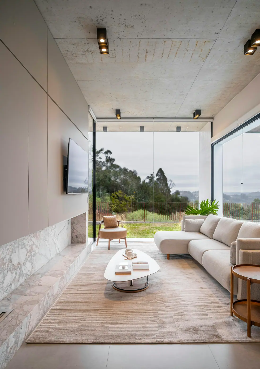 Modern living room with floor-to-ceiling windows and a wall-mounted television